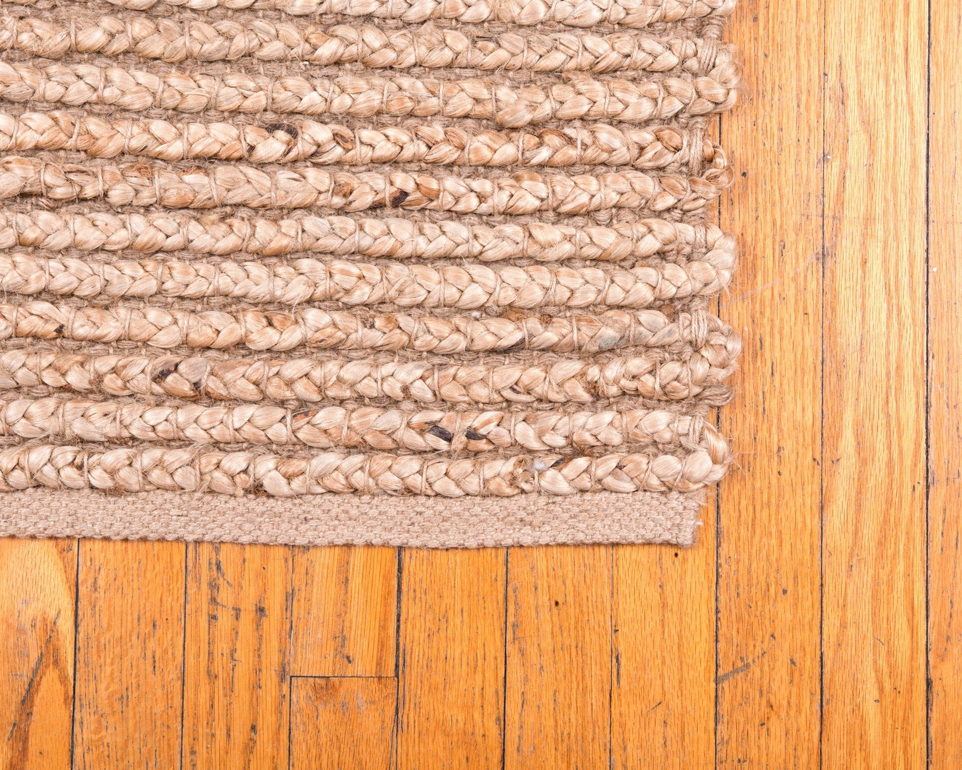 a braided jute rug on a hardwood floor