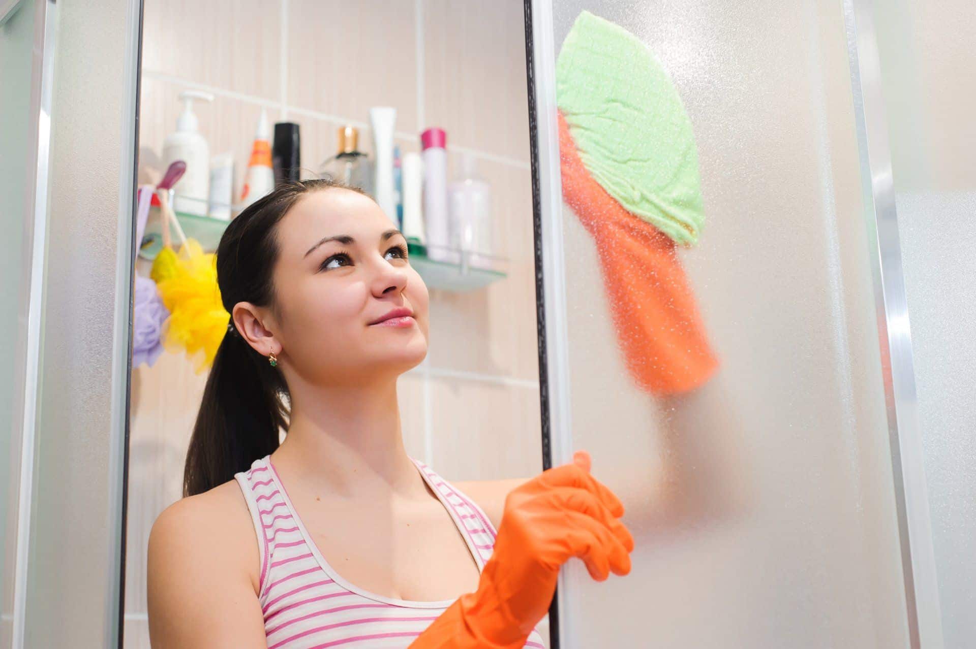 9 Things You Can Clean While Working Remotely 6 woman cleaning a shower