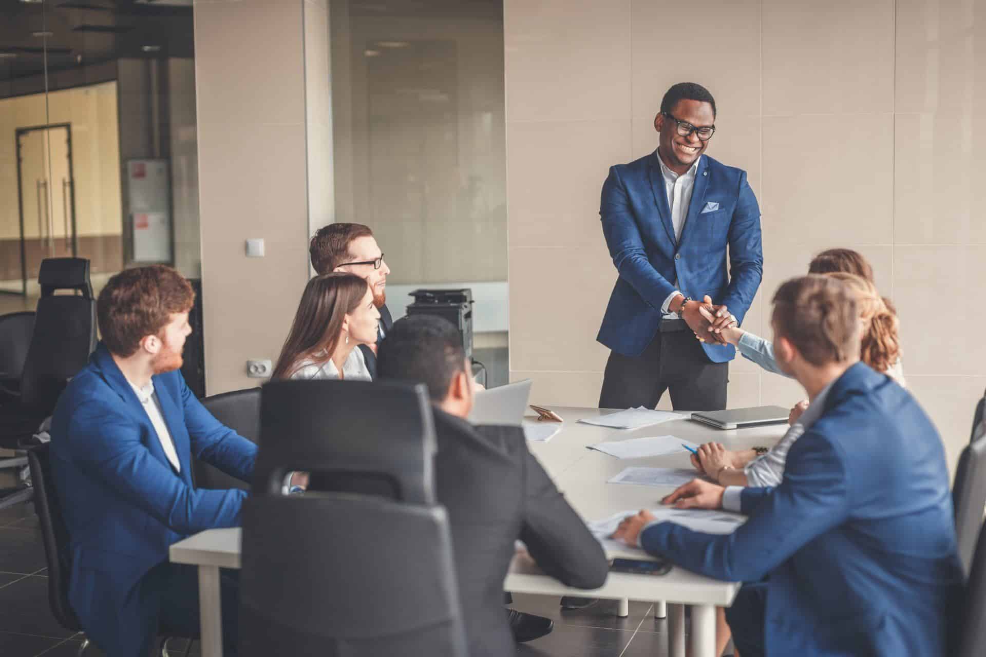man shaking the hand of a woman at a business meeting