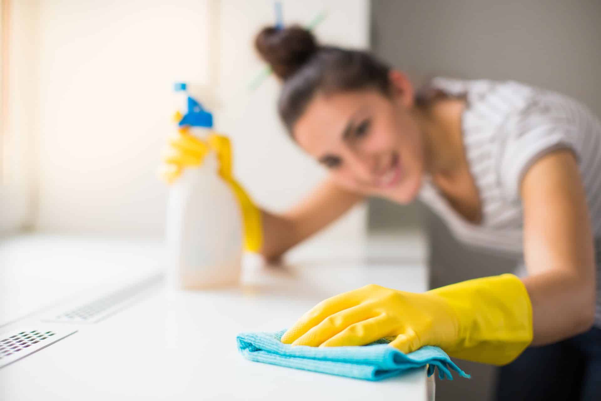 woman cleaning with bleach in yellow gloves