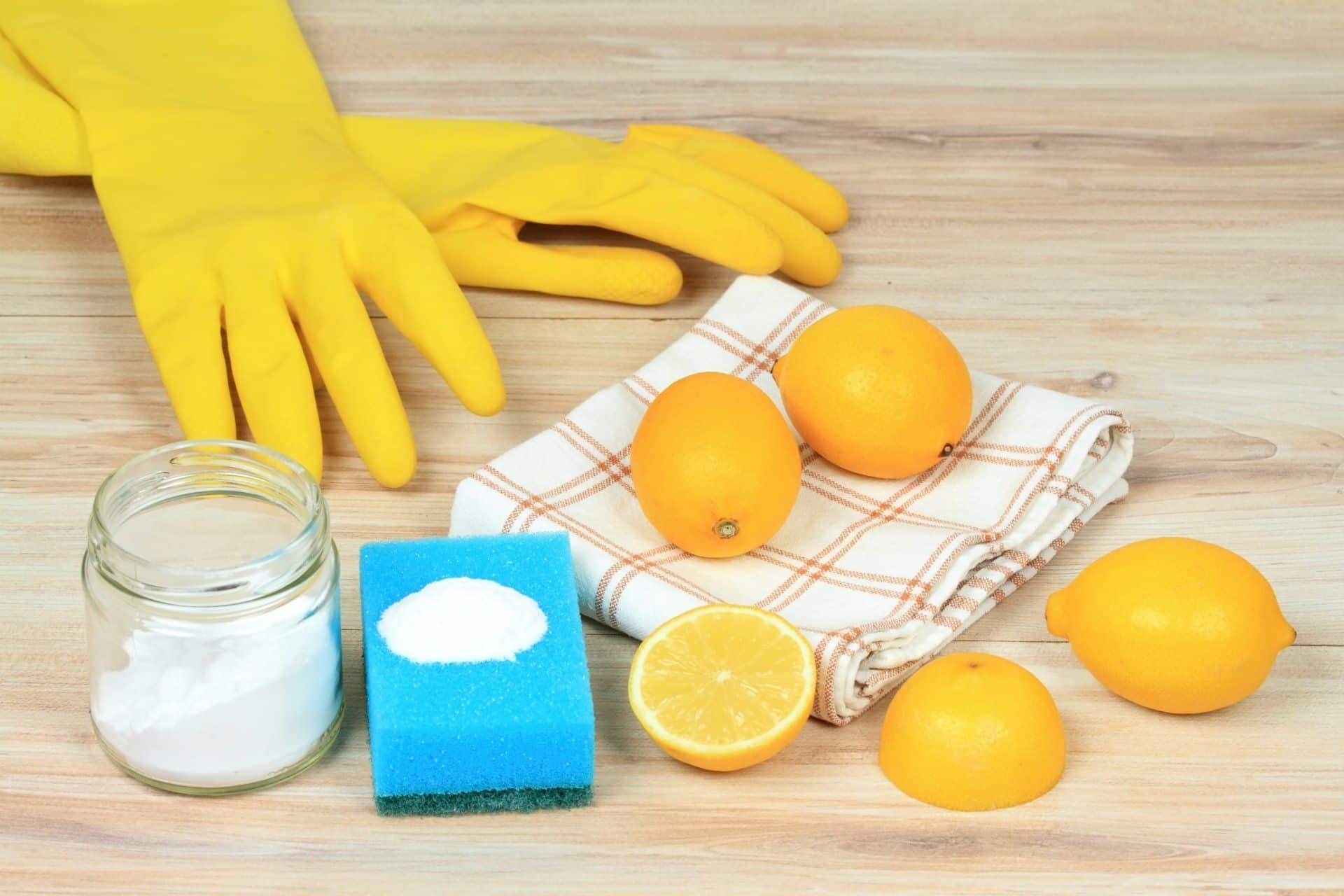 yellow cleaning gloves, lemons, dish towel, baking soda and blue sponge