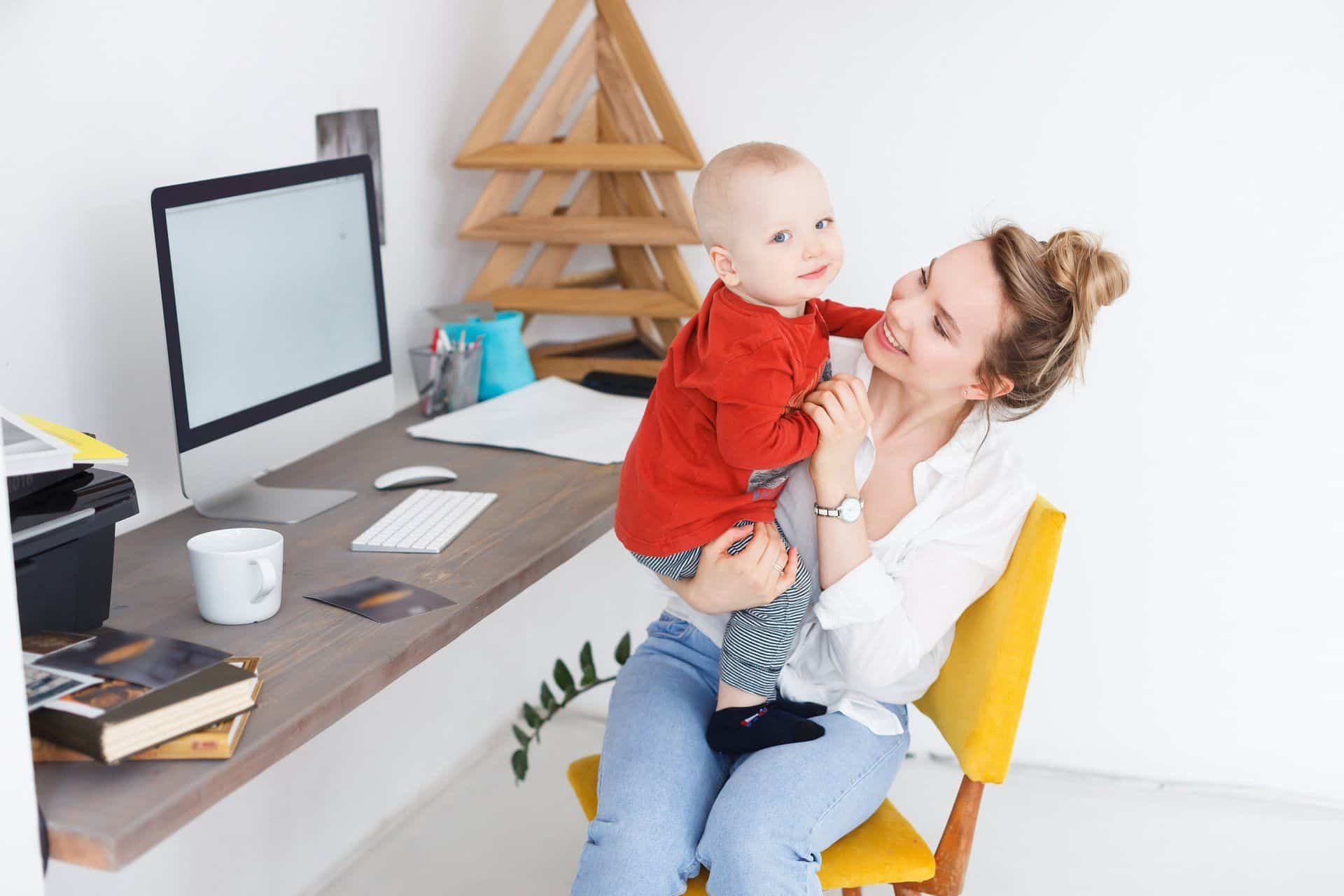 9 Things You Can Clean While Working Remotely 2 woman working remotely and holding her toddler