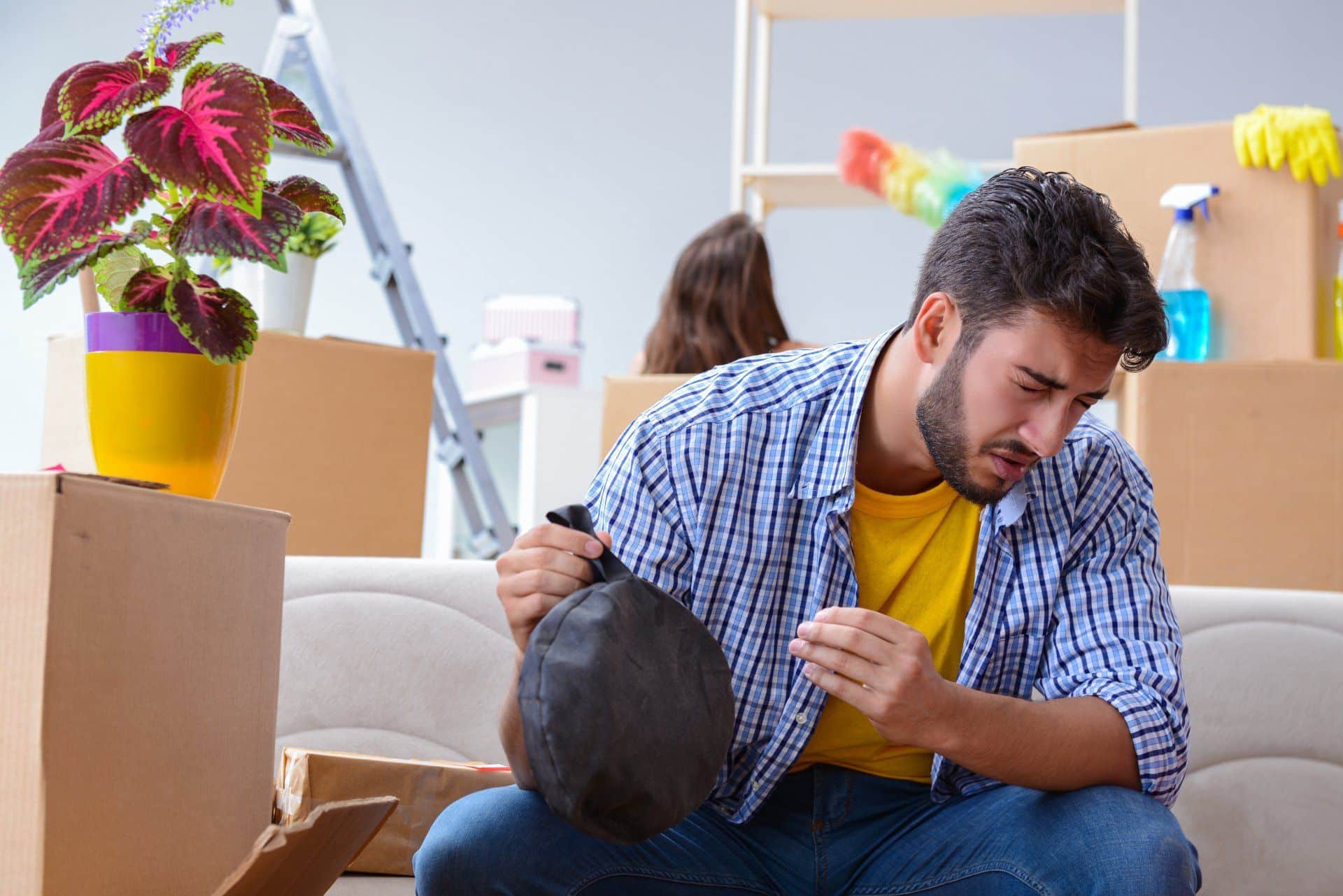 man holding a whoopie cushion with a look of detest on his face