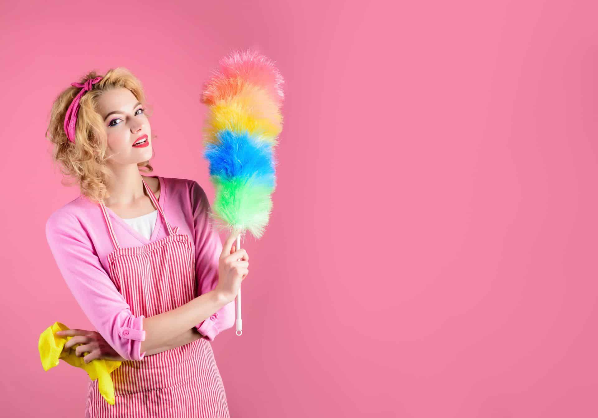 7 Cleaning Resolutions to Start Your New Year Off Right 4 woman dressed in pink holding a rainbow colored feather duster