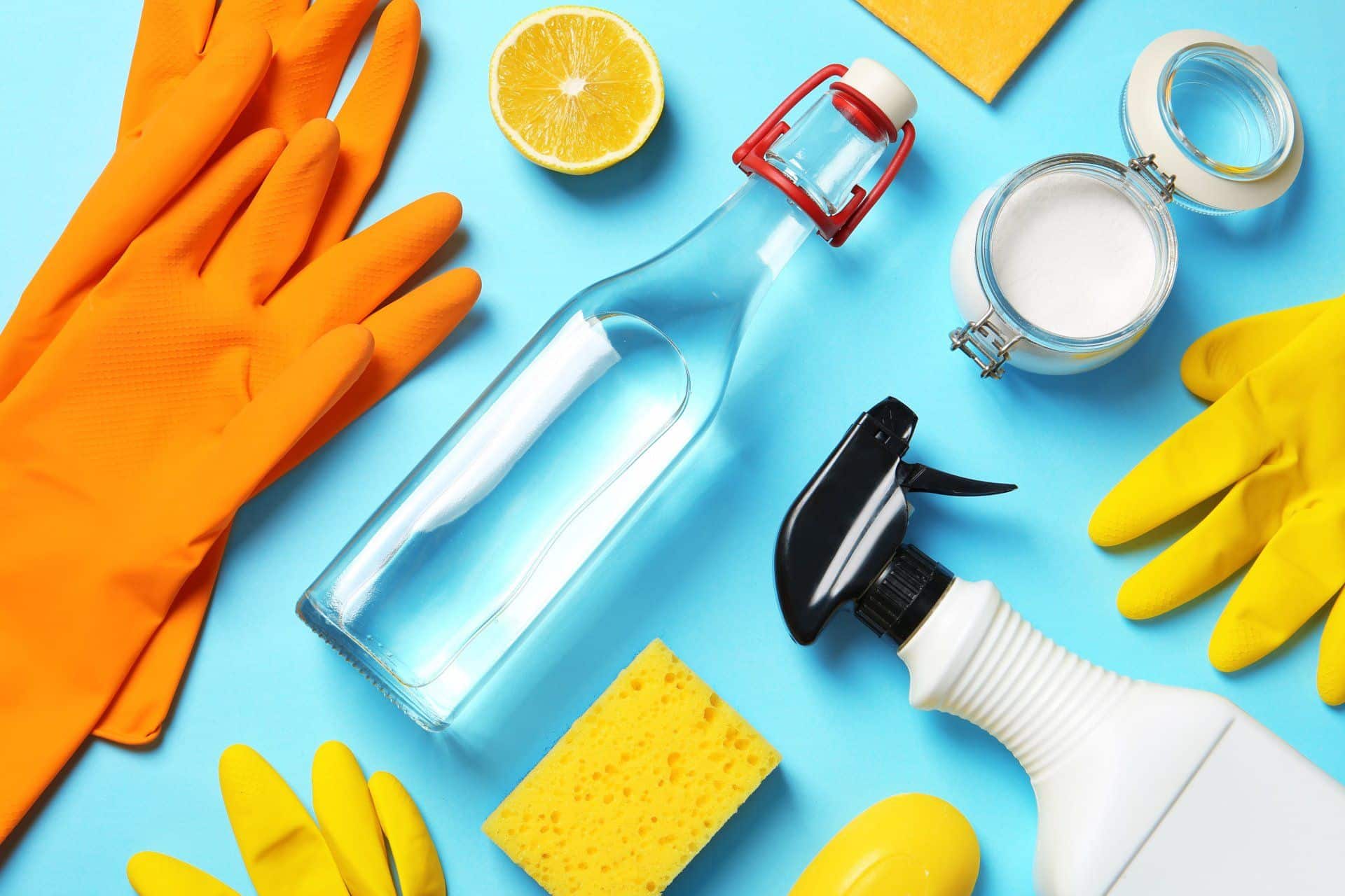 vinegar, cleaning gloves, spray bottle, baking soda and sponge flat lay