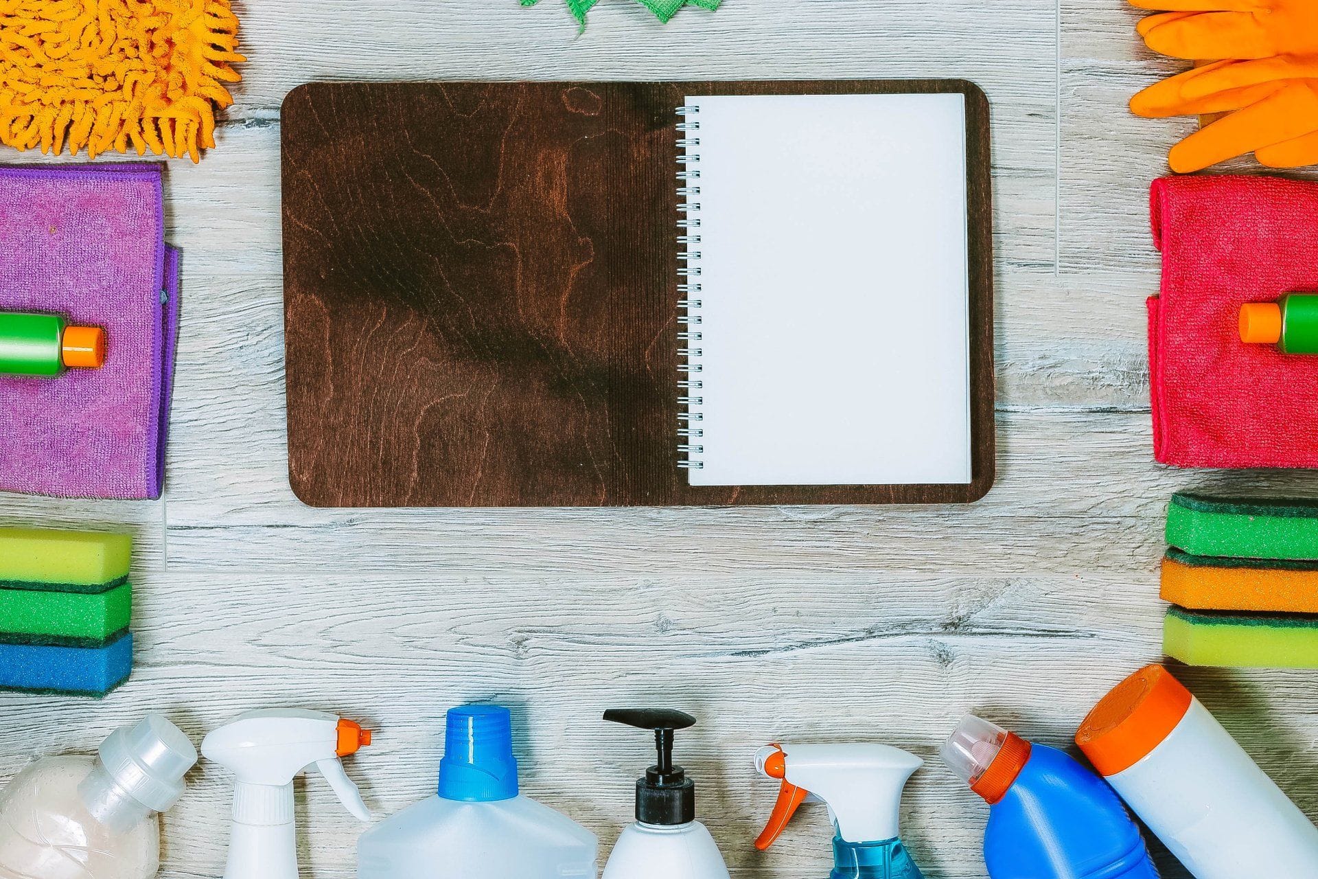 empty open notebook surrounded by cleaning supplies