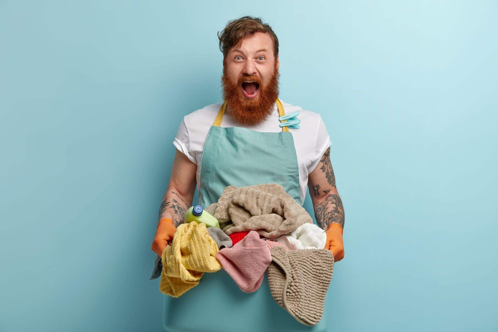 man with a look of surprise on his face holding up laundry