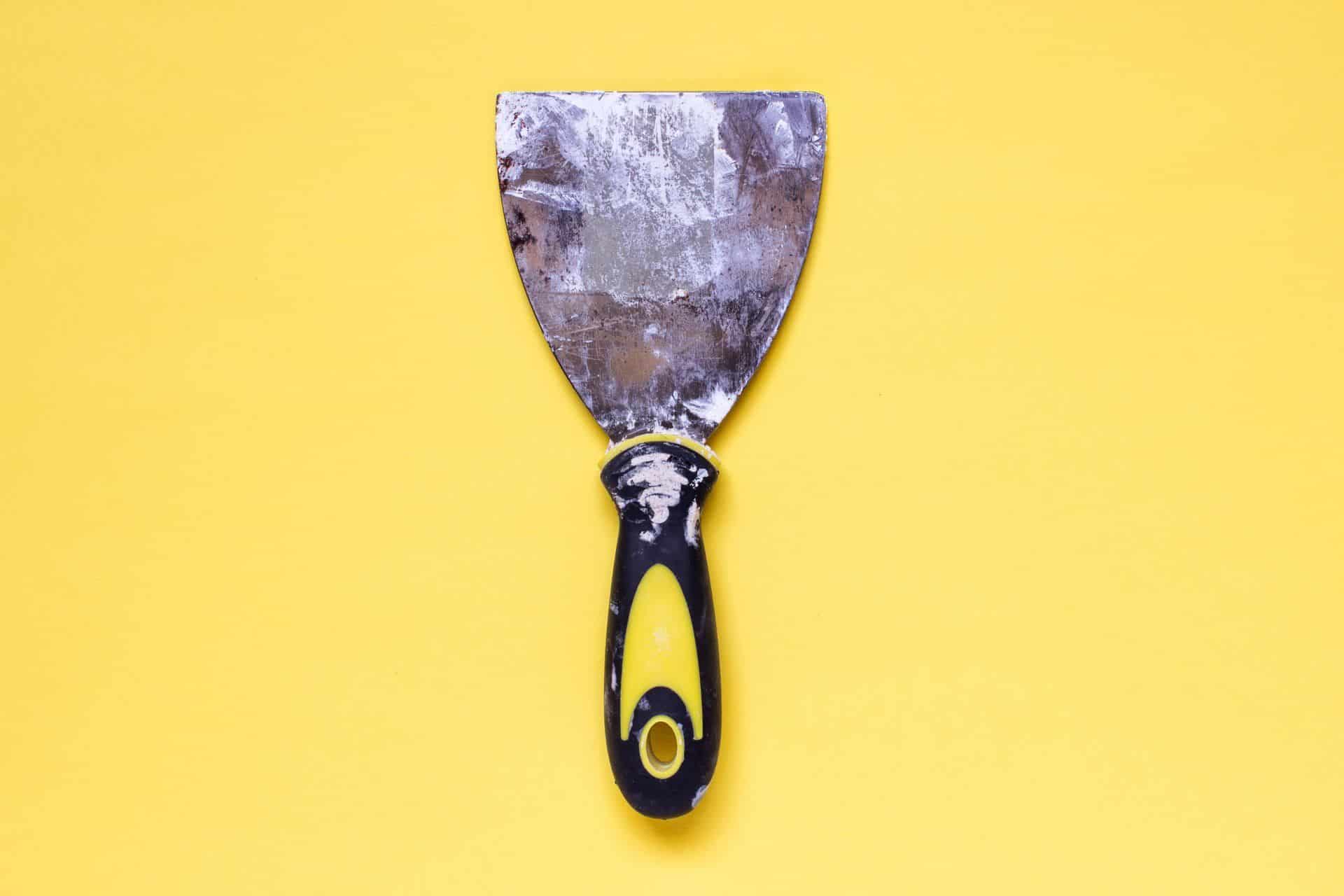 a tool for spackle on a yellow background