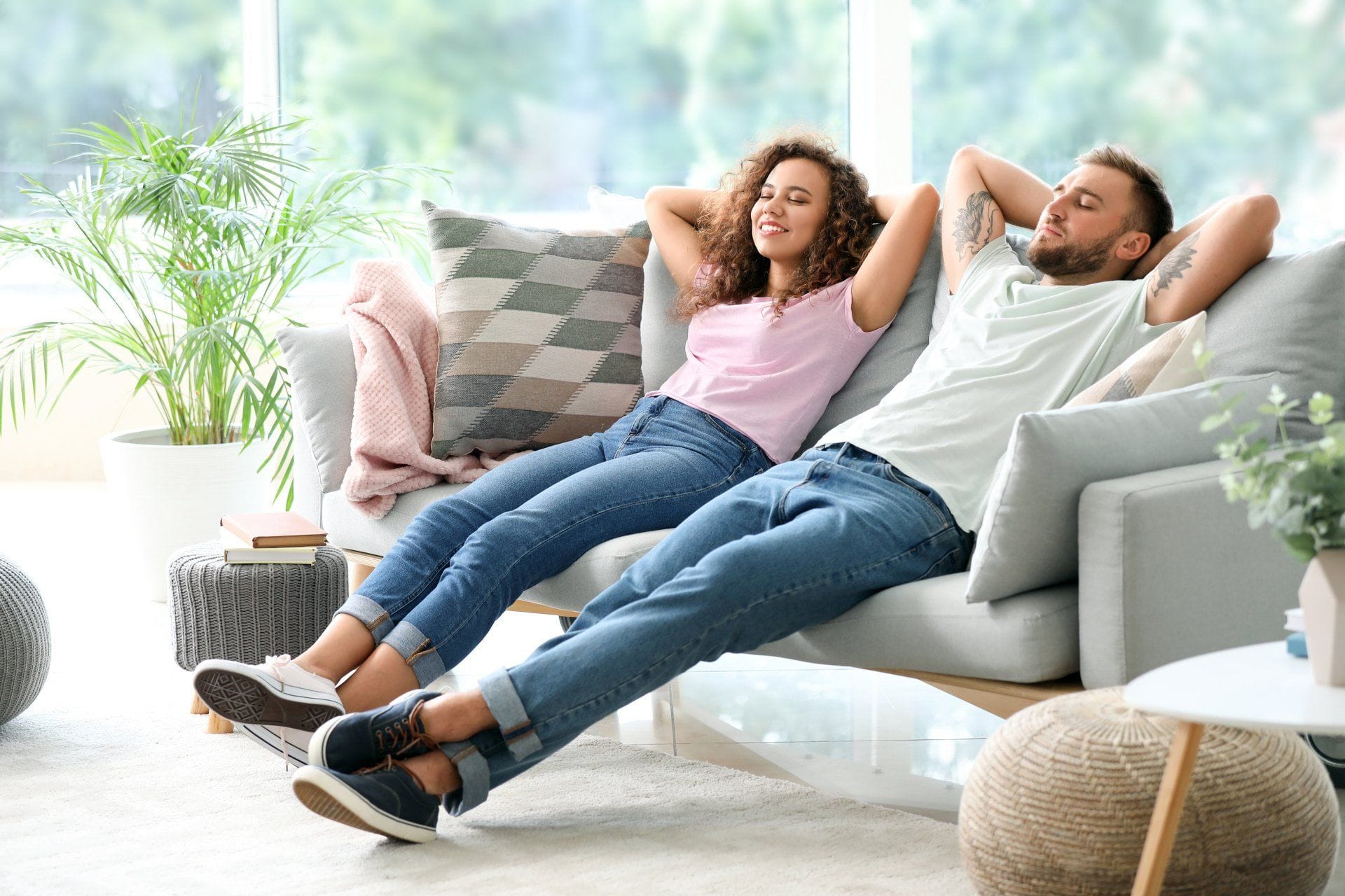 a couple laying back and relaxing on their couch in their clean home