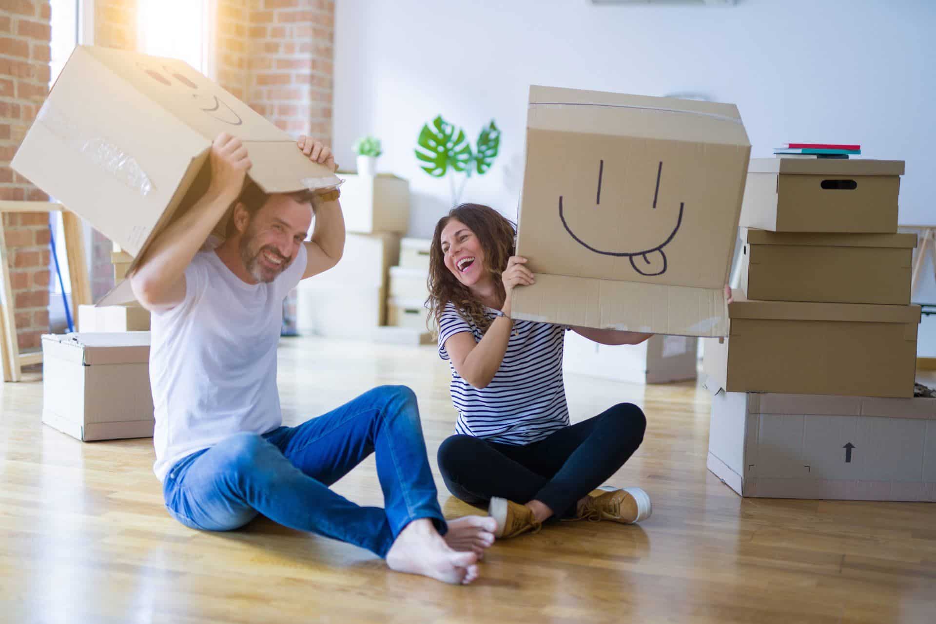 coupe removing smile face boxes from their heads and laughing