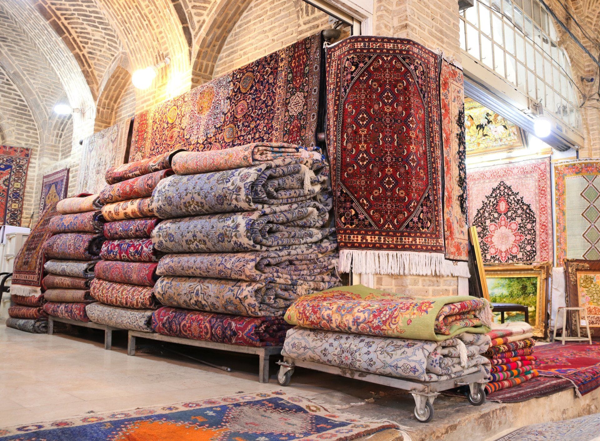 an oriental rug store filled with folded and hanging rugs
