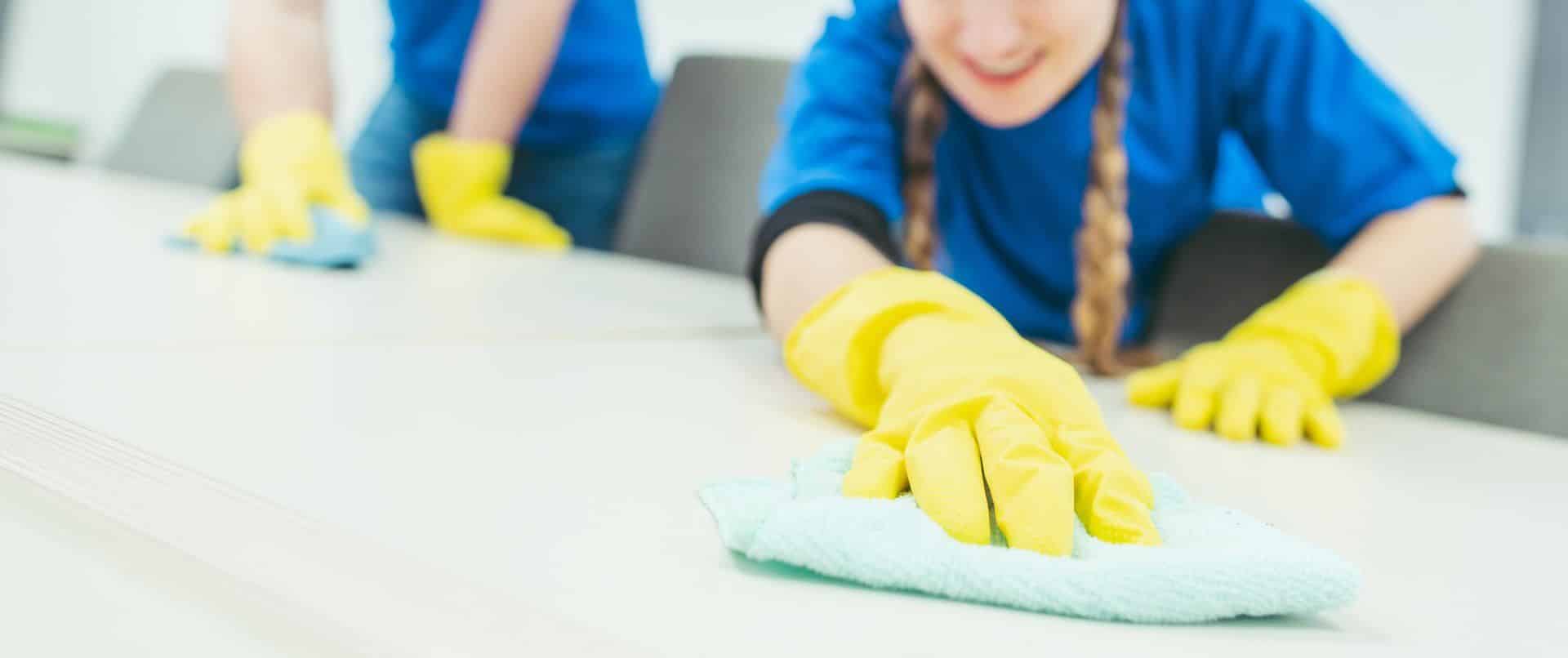 people with yellow rubber loves cleaning a surface with microfiber towels