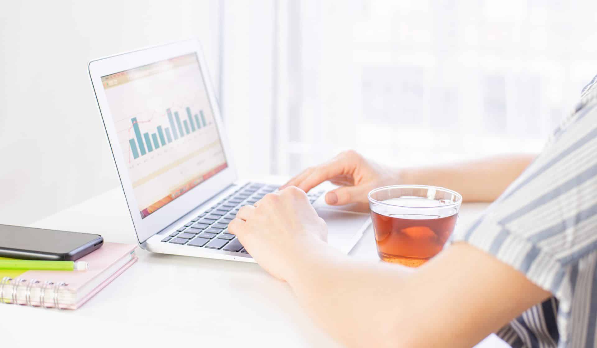 9 Things You Can Clean While Working Remotely 1 a person having tea while working remotely on their computer