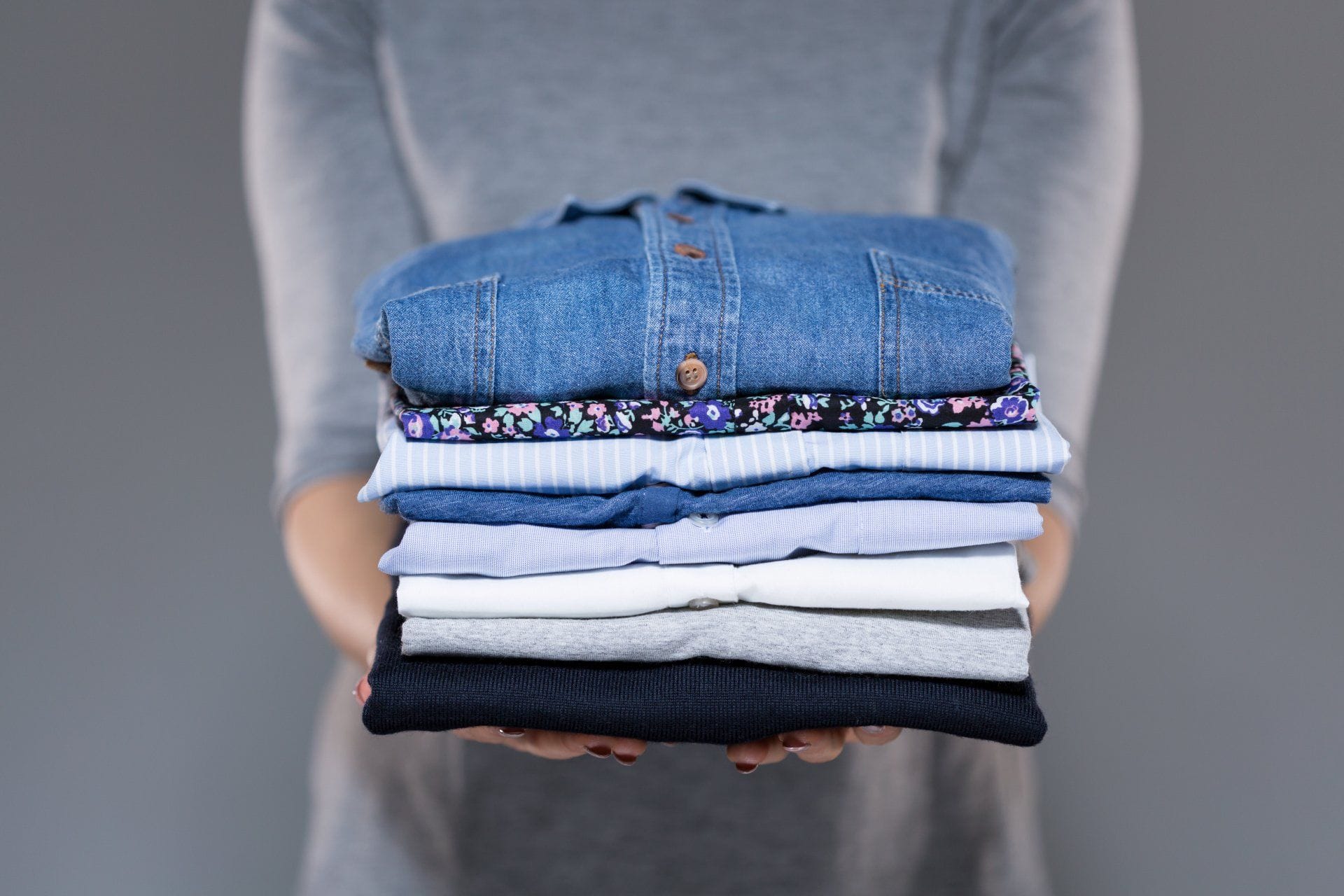 A Weekly Cleaning Schedule That's Quick and Easy 9 Holding Folded Clothes