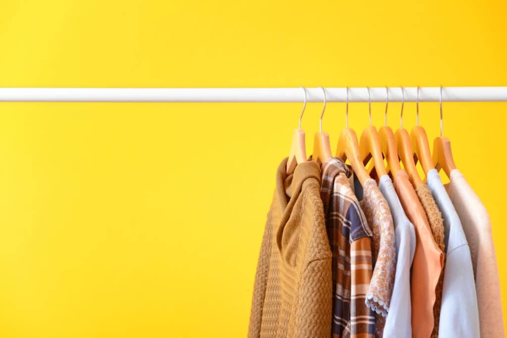An organized hall closet on a yellow background.