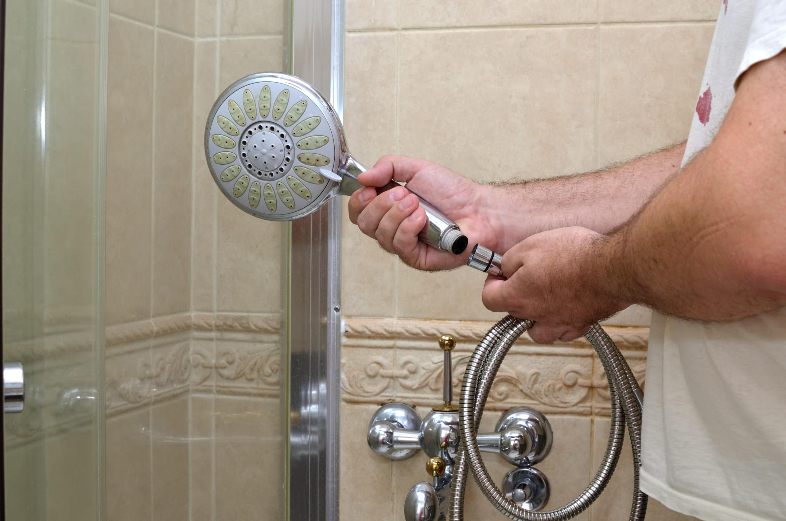 How to Clean a Shower Head 6 Someone removing a showerhead to learn how to clean a showerhead