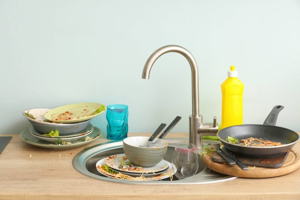 A sink full of dirty dishes. How do you get rid of fruit flies? Clean up troublesome food mess.