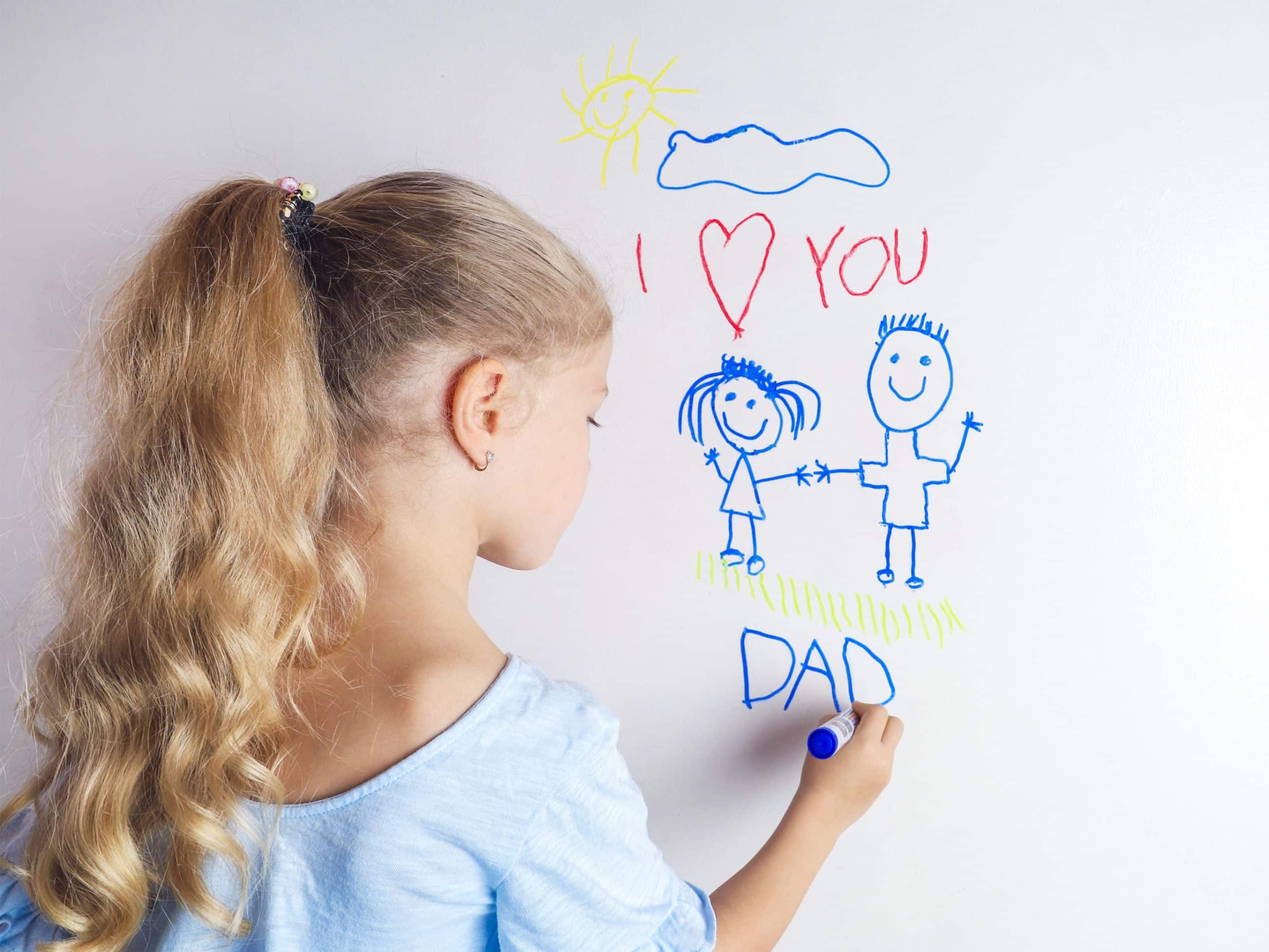 A girl drawing on a wall with marker