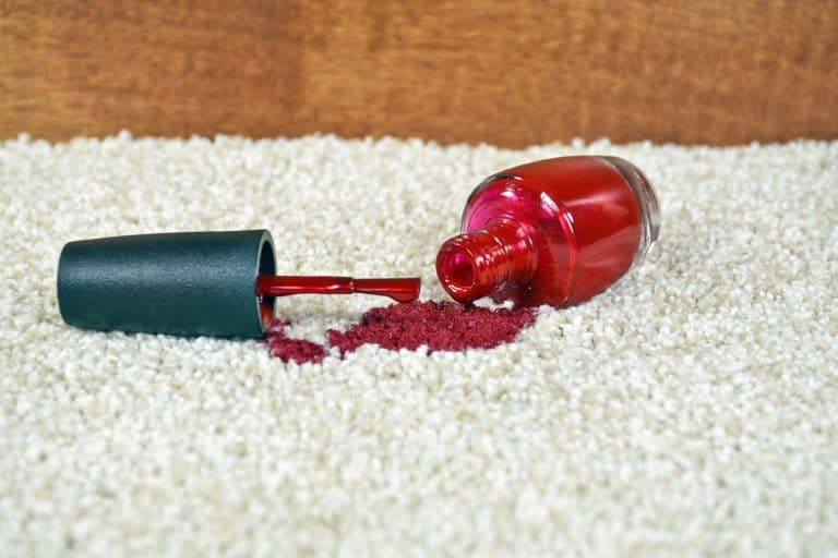 Red nail polish tipped over and spilled on to carpet.