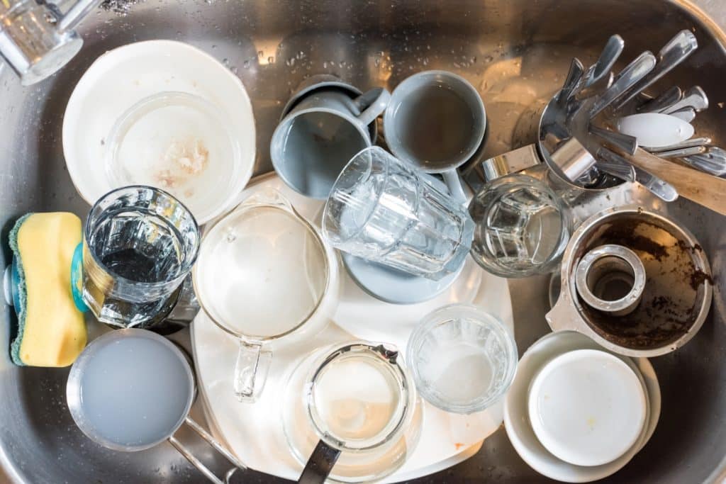 A sink full of dirty dishes that need to be washed.