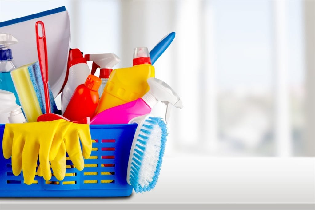 A blue basket filled with house cleaning tools.