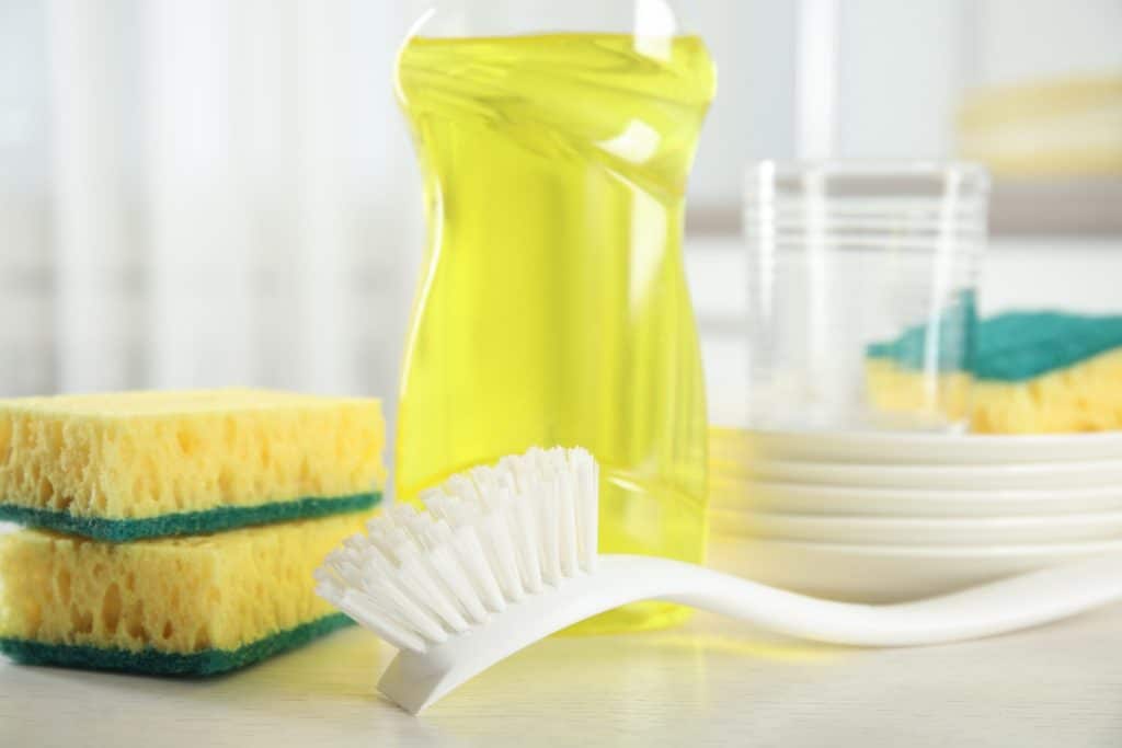 A dish brush with sponges and dish soap.