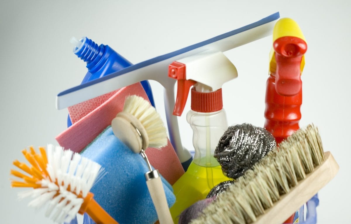 A bucket filled with house cleaning tools.