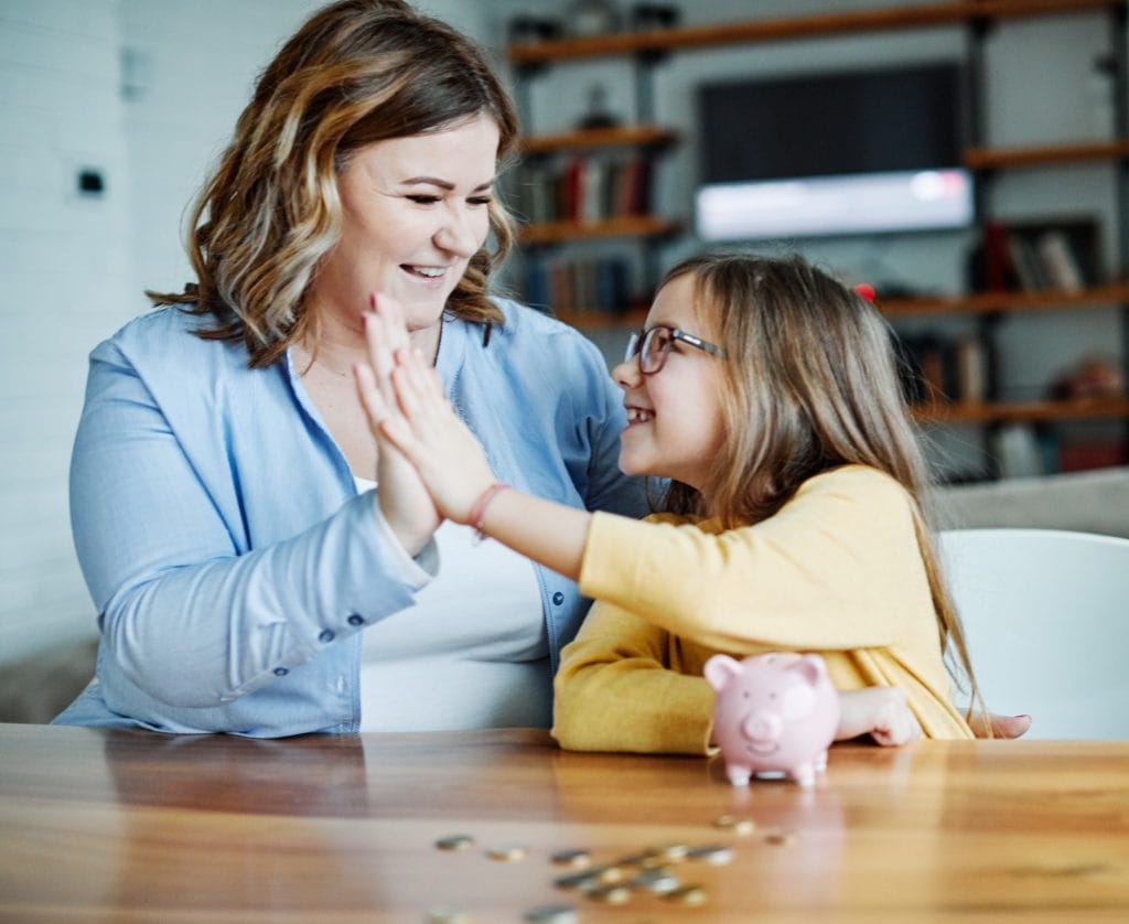 A mom teaching her young daughter baout money and how to budget