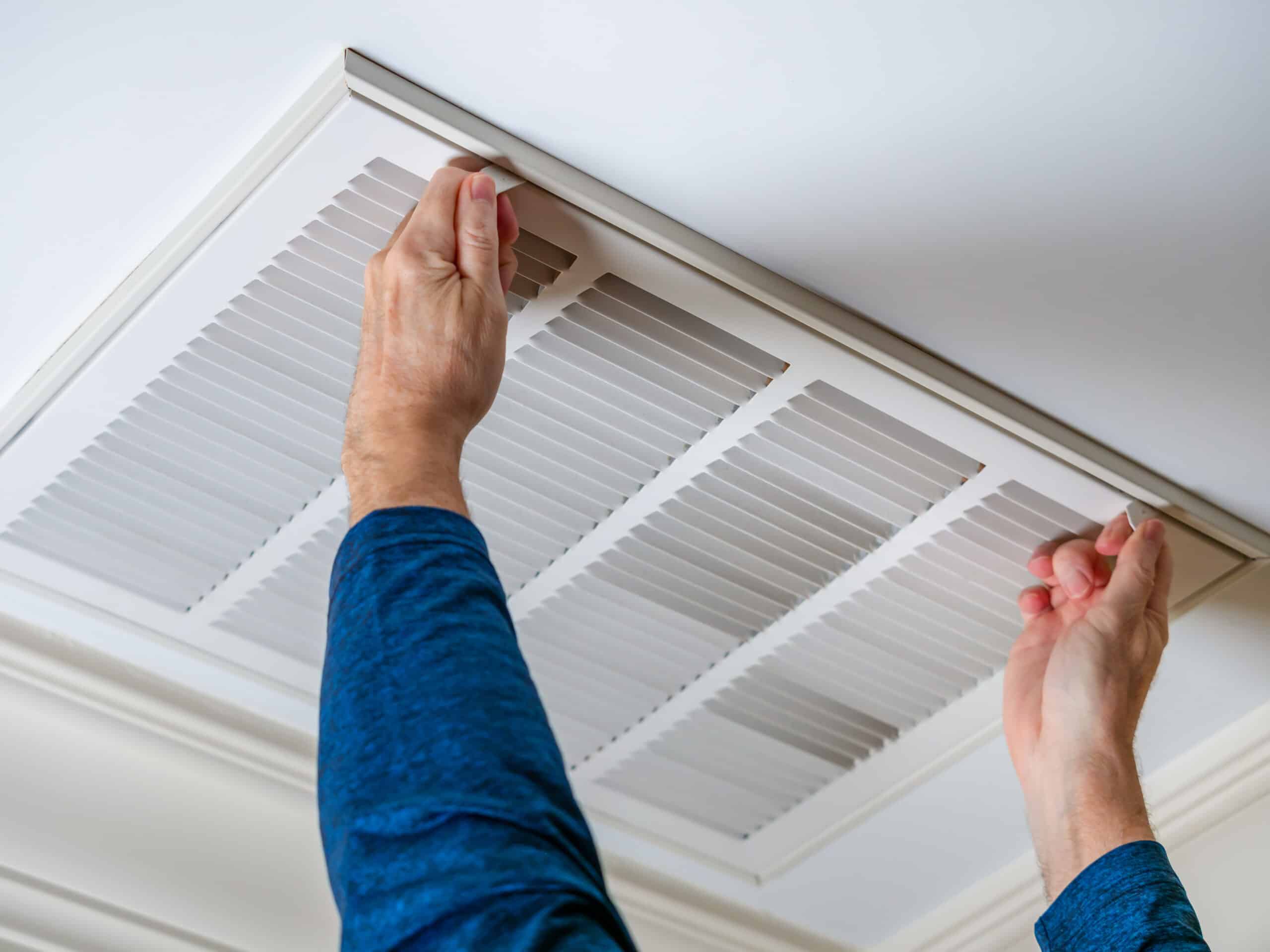 Winter Home Maintenance - Man opening ceiling air vent 